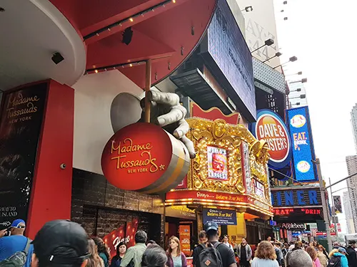 Gente caminando por calles de Times Square frente a Madamme Tussauds - Foto de AHM
