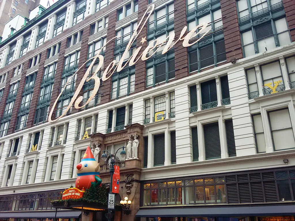 Fachada principal de Macys Herald Square en la época navidadeña. Letrero lumínico: believe - Foto de AHM