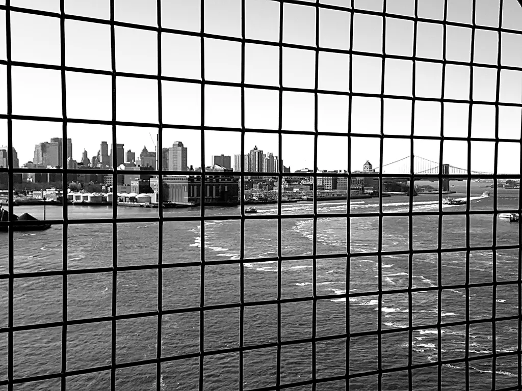 Puentes de Manhattan y Brooklyn vistos detrás de las rejas del cruce peatonal del Puente de Williamsburg - Foto de Andrea Hoare Madrid