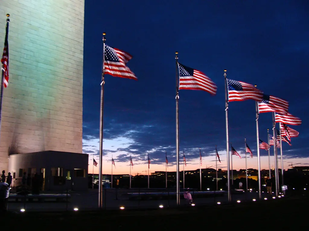 Flags around the Washington Monument obelisk at sunset - Photo by Andrea Hoare Madrid