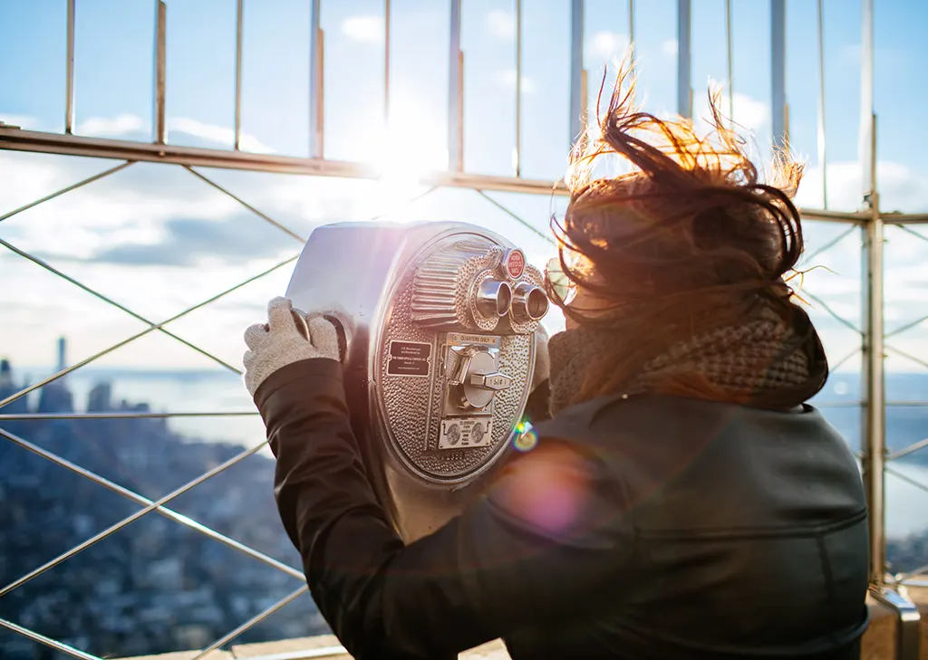 Mujer observando desde el Mirador del Empire State. Photo by Freddy Marschall on Unsplash. Guía de los mejores miradores en New York.