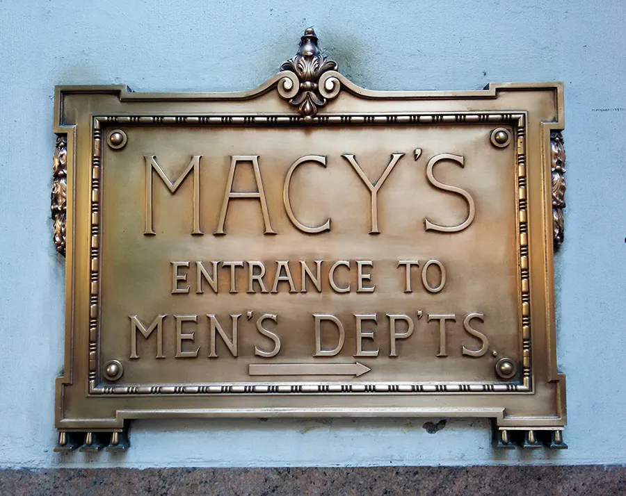 Antiguo letrero de bronce de macy's indicando la entrada del departamento de hombres - Foto de Andrea Hoare Madrid