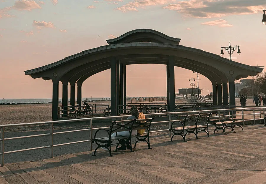 Gente sentada frente al mar en el Boardwalk entre Coney Island y Brighton Beach en Brooklyn. Foto de Lasha Senashvili en Unsplash disponible en https://unsplash.com/photos/BQKDp8u4qmo