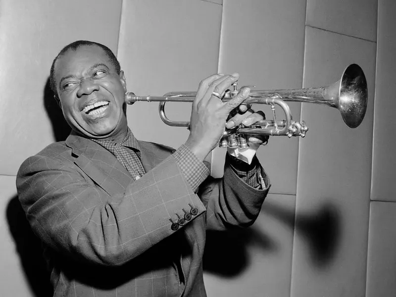 Foto de Louis Armstrong de Dominio Público. Herbert Behrens / Anefo, CC0, via Wikimedia Commons disponible en https://commons.wikimedia.org/wiki/File:Louis_Armstrong_(1955).jpg