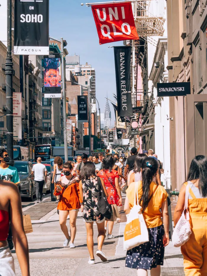 Gente transitando por las calles del SoHo llenas de tiendas y locales comerciales. Foto de Yoav en Unsplash disponible en https://unsplash.com/photos/jws-3Pb7jps