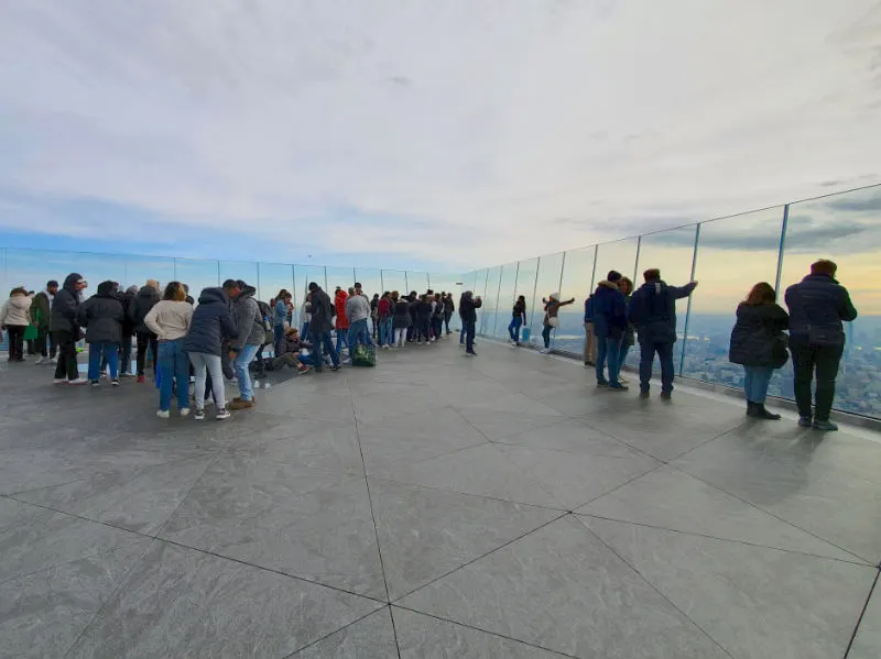 Personas mirando a través de los cristales de la terraza al aire libre del mirador The Edge. Foto de AHM