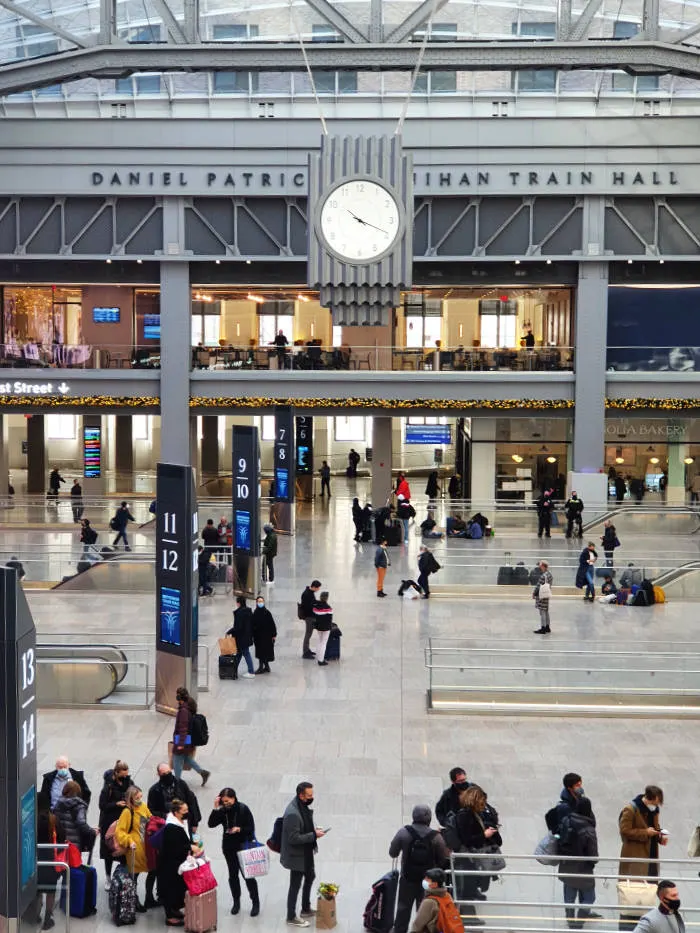 Personas esperando trenes en la Moynihan Train Hall de Penn Station - Foto de Andrea Hoare Madrid