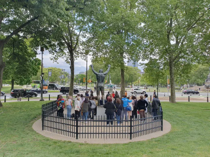 Lugar de la Estatua de Rocky junto a las escaleras del Museo de Arte de Filadelfia vista desde atrás. Hay varias personas esperando su turno para fotografiarse junto a uno de las estatuas más famosas de Philadelphia- Foto de Andrea Hoare Madrid