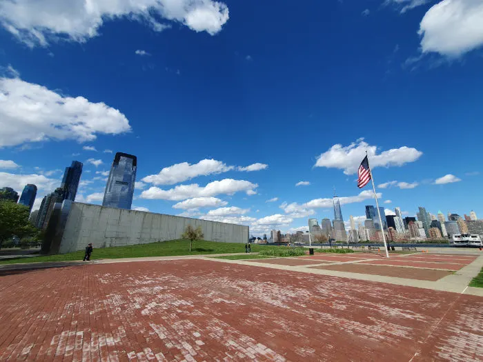 Esplanada del Liberty State Park en New Jersey, a la izquierda se ven edificios de Jersey City y a la derecha el perfil del Sur de Manhattan, destacando el edificio One World Trade Center. Foto de Andrea Hoare Madrid