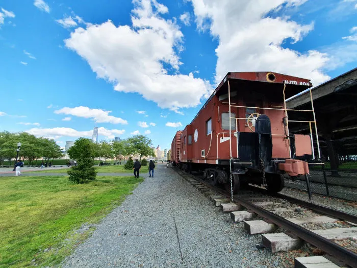 Antiguo ferrocarril expuesto al exterior de la Central Railroad of New Jersey en el Liberty State Park de Jersey City. Al fondo se destaca el edificio One World Trade Center de Manhattan- Foto de Andrea Hoare Madrid