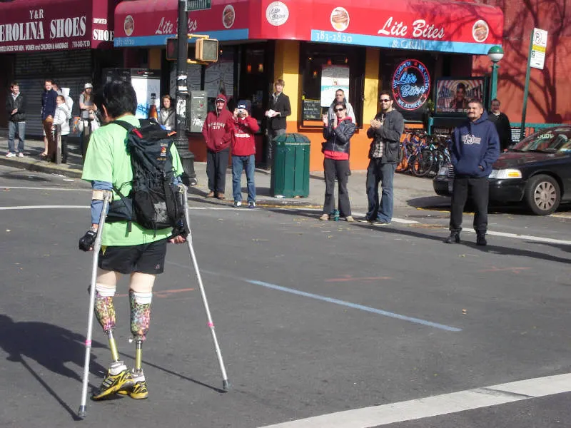 Personas aplaudiendo a un atleta con prótesis en sus piernas, durante la carrera del Maraton de la ciudad de New York - Foto de Andrea Hoare Madrid