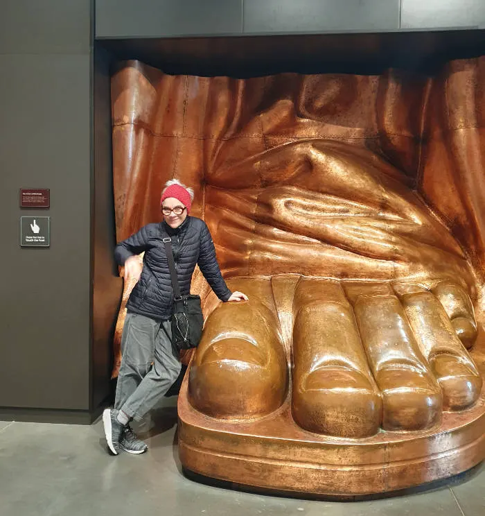 Andrea Hoare junto a una réplica del pie de la Estatua de la Libertad expuesta dentro del Museo de la Isla - Foto de Marina Madrid