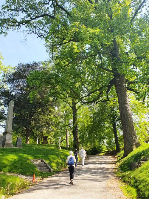 Personas paseando a través de un sendero lleno de árboles centenarios del Cementerio Histórico Greenwood en Brooklyn - Foto de Andrea Hoare Madrid