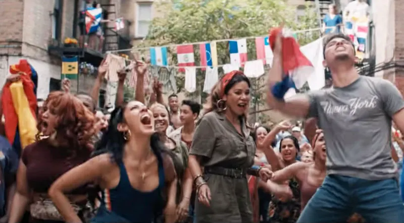 Captura de un momento de la escena Fly the Flag en la Película hecha en Nueva York: In The Heights. Los actores bailan con banderas de toda latinoamérica en en sus manos (barrio Washington Heights). Top 21 de Películas filmadas en Nueva York