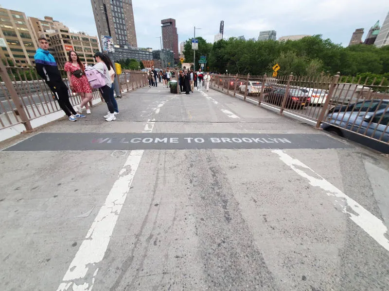 Camino de asfalto que une la pasarela del Puente de Brooklyn con las calles de DUMBO. En el suelo se lee una placa grabada que dice "Welcome to Brooklyn" Foto de Andrea Hoare Madrid