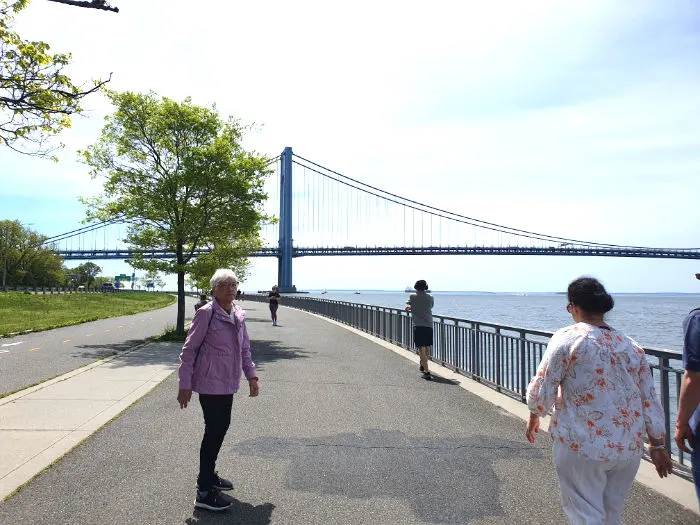 Personas caminando junto al mar en el Shore Road Park en Bay RIdge. Al fondo se distingue el Puente de Verrazano-Narrows. Foto de Andrea Hoare Madrid