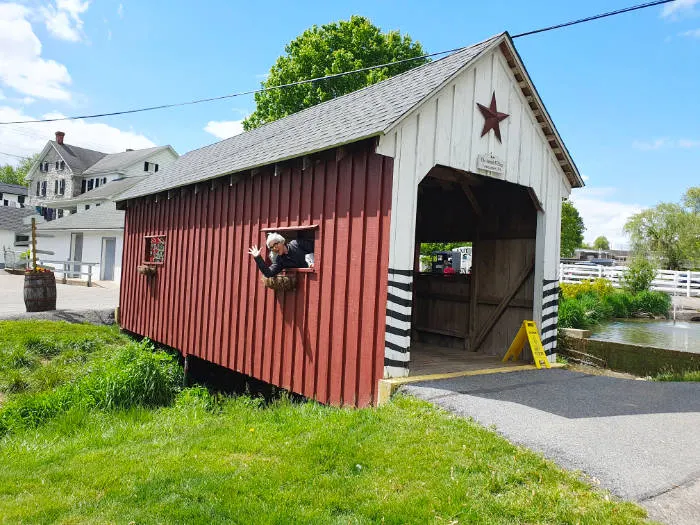 Andrea Hoare asomada en la ventana de un puente de madera techado de en la Amish Village, centro de interpretación Amish en Lancaster, Pensilvania. Foto de Marina Madrid