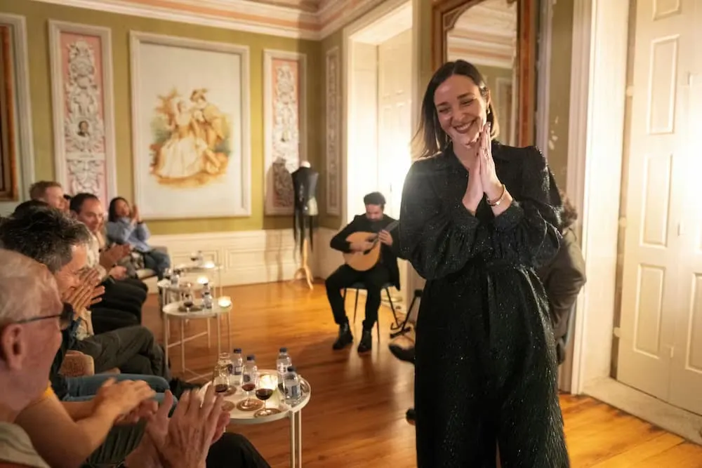 Fado singer thanking the audience in a 19th-century mansion room at Destino Fado, Porto