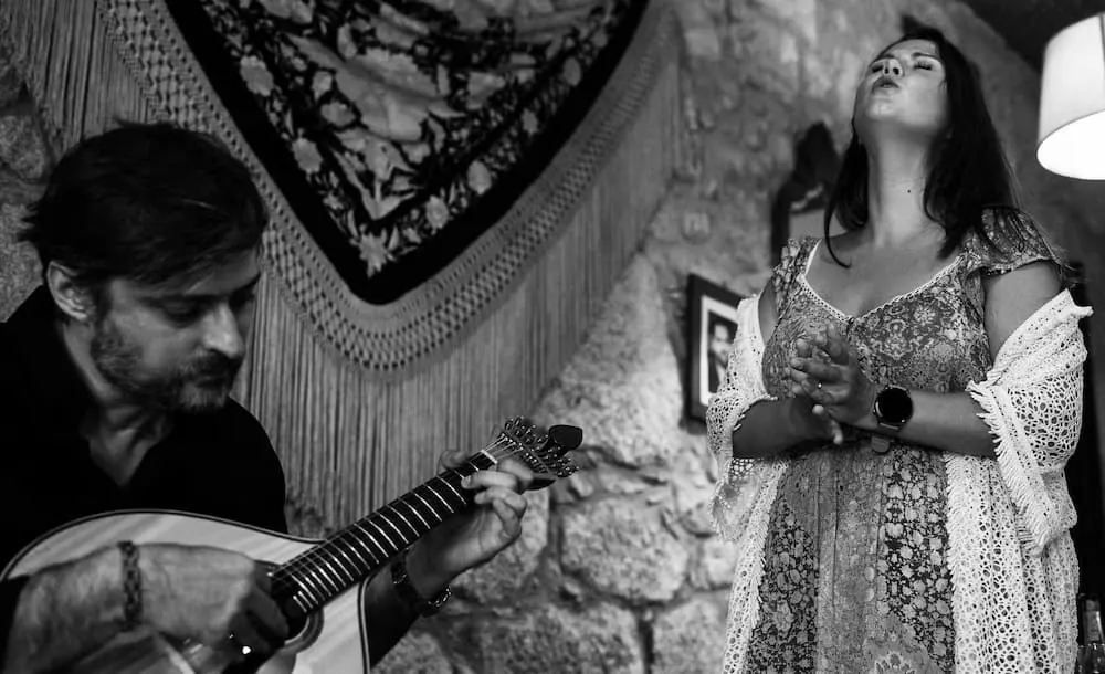 Black and white photo of a Fado singer and a Portuguese guitar player at Fado na Baixa