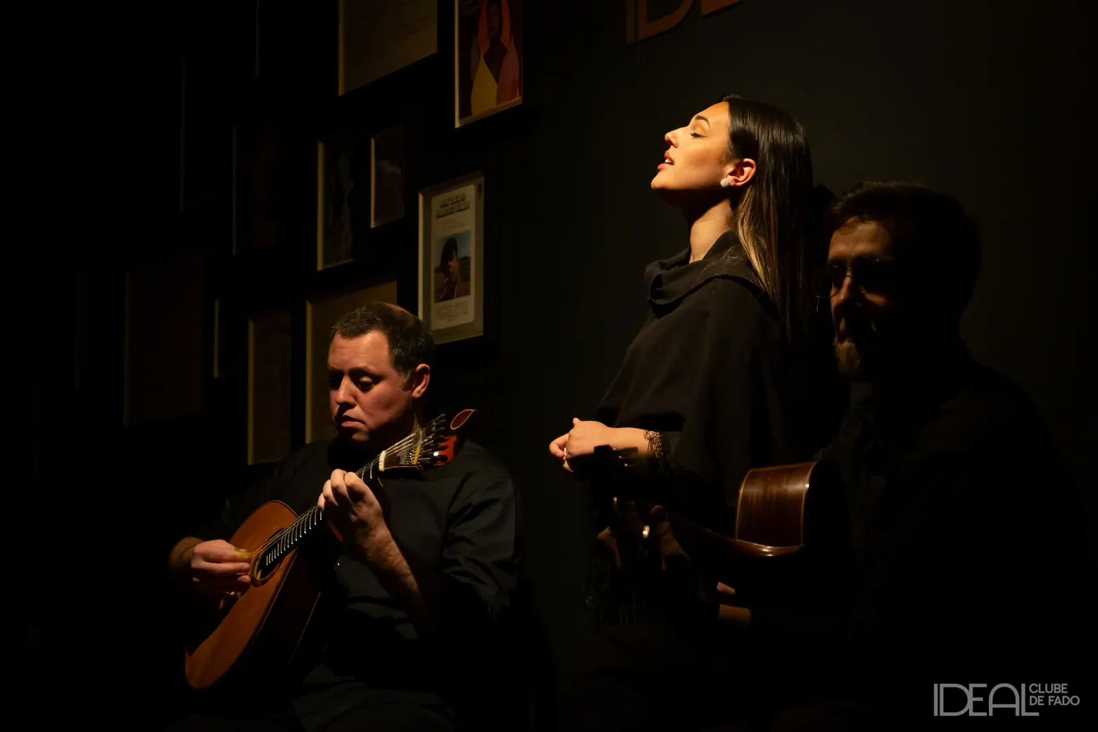 Singer and Portuguese guitar player during a concert at Ideal Clube de Fado in Porto