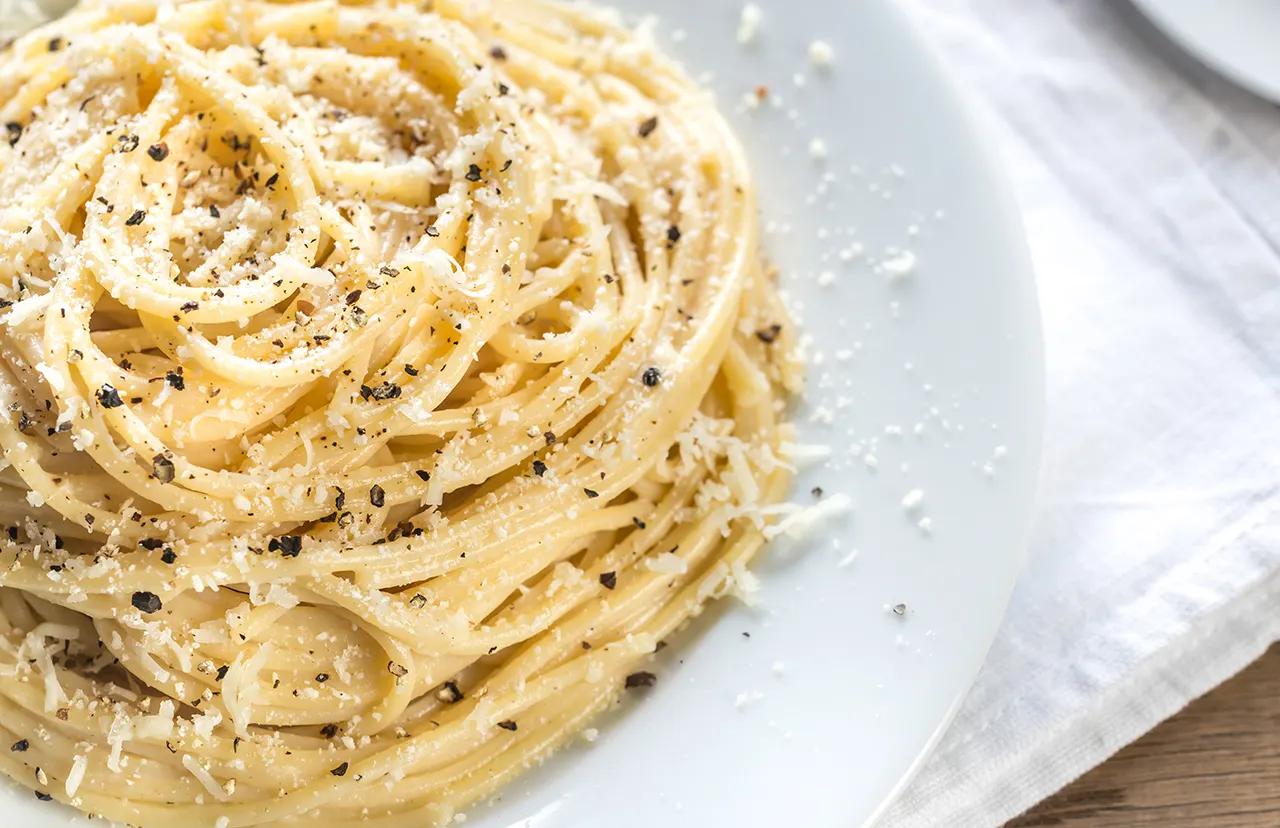 Plato de pasta Cacio e Pepe con queso y pimienta.