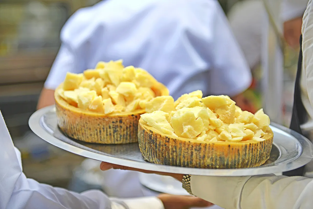 Queso Grana Padano recién cortado en rueda