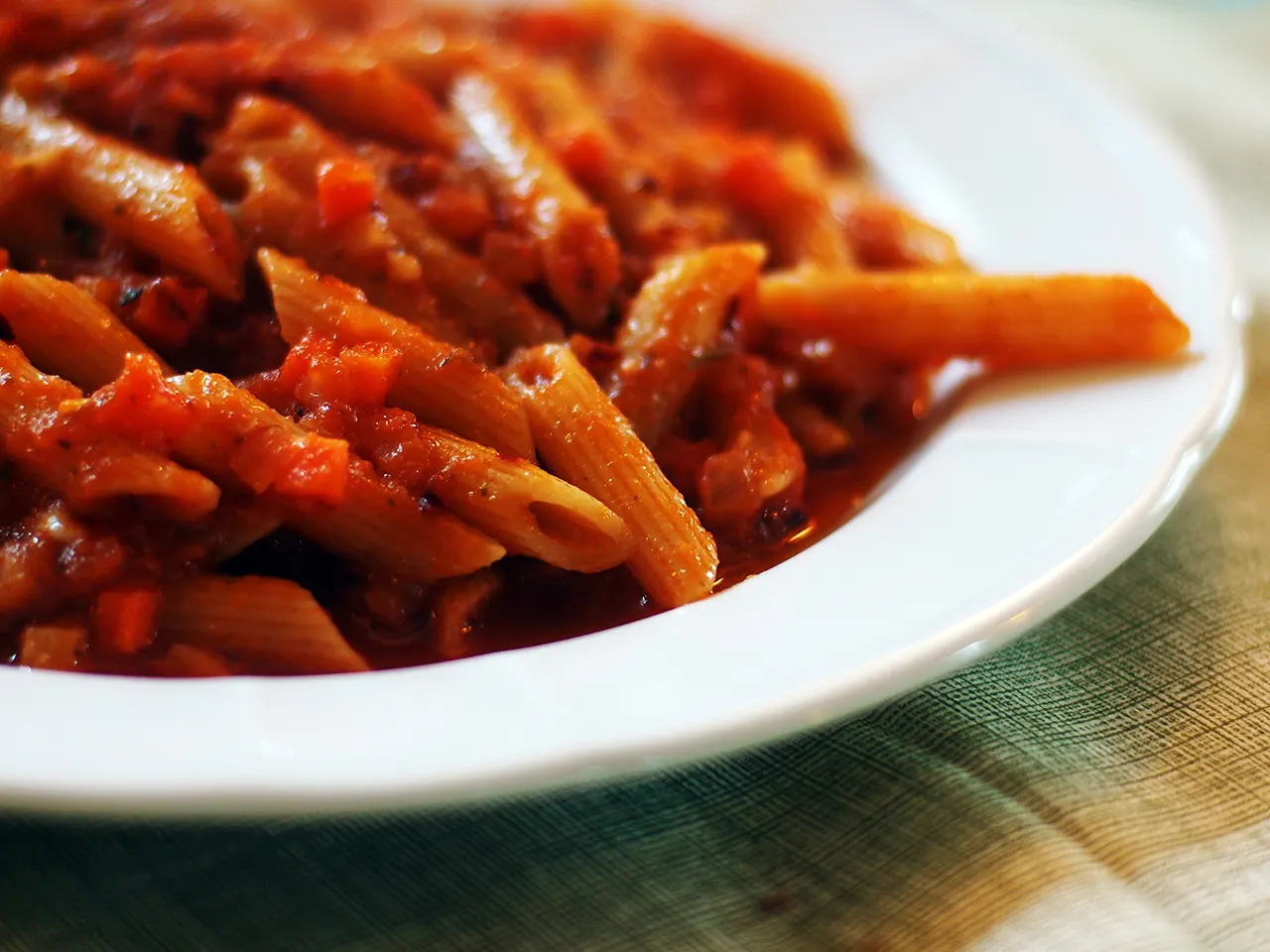 Penne all'arrabbiata en plato blanco.