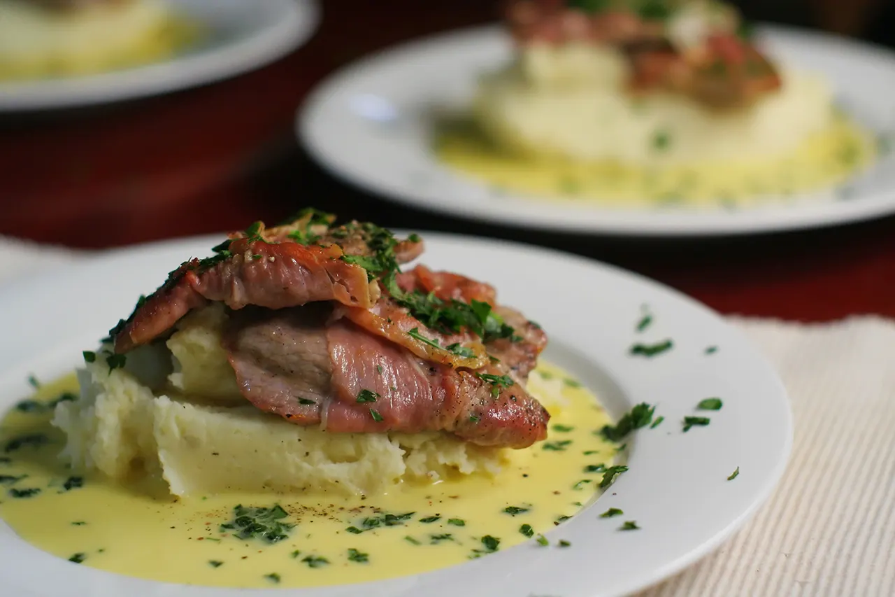 Scaloppine de ternera con salsa y puré de patatas.