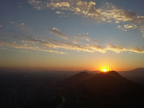 Puesta de sol detrás del Cerro San Cristóbal vista desde el Mirador de la Gran Torre Santiago - Foto de Andrea Hoare Madrid