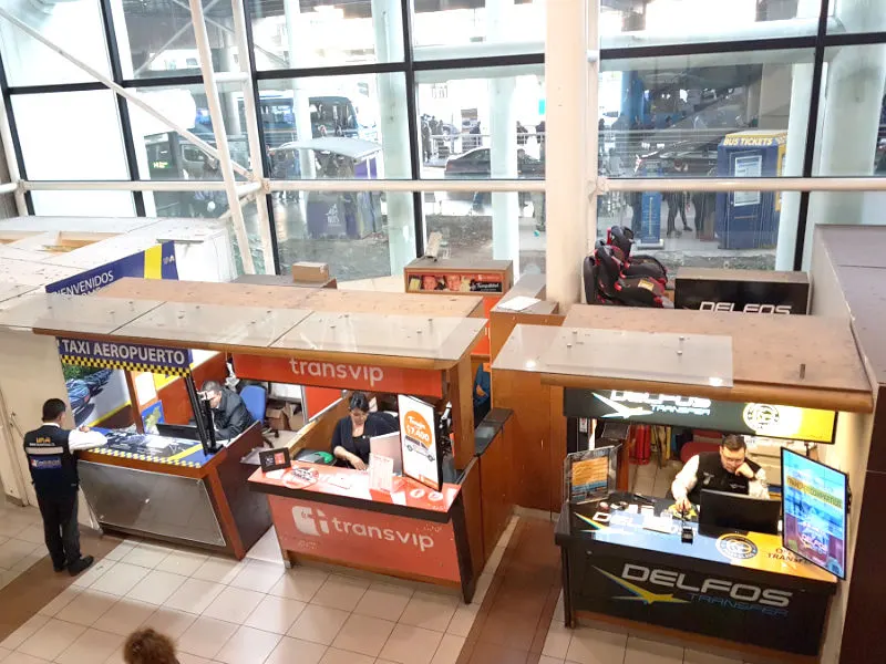 Puestos para contratar taxis oficiales y transfer compartidos en el Aeropuerto de Santiago, Pudahuel - Foto de AHM