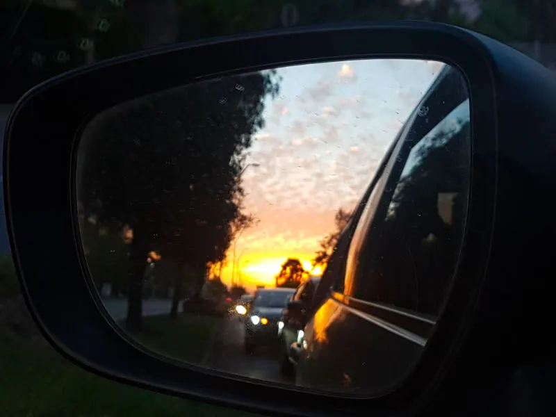 Vista por el espejo retrovisor de un auto de un típico atardecer de verano en Santiago - Foto de Andrea Hoare Madrid