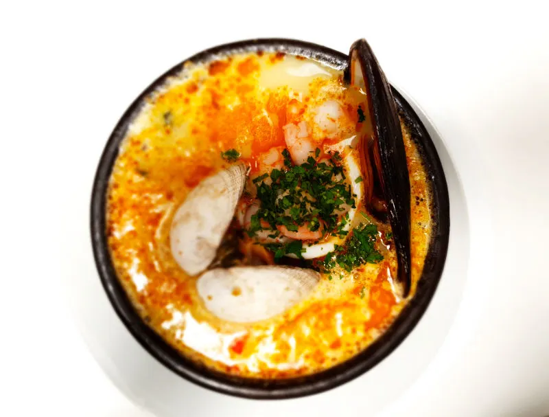 Paila marina en plato de greda, preparación típica chilena a base de pescados y mariscos - Foto de Andrea Hoare Madrid