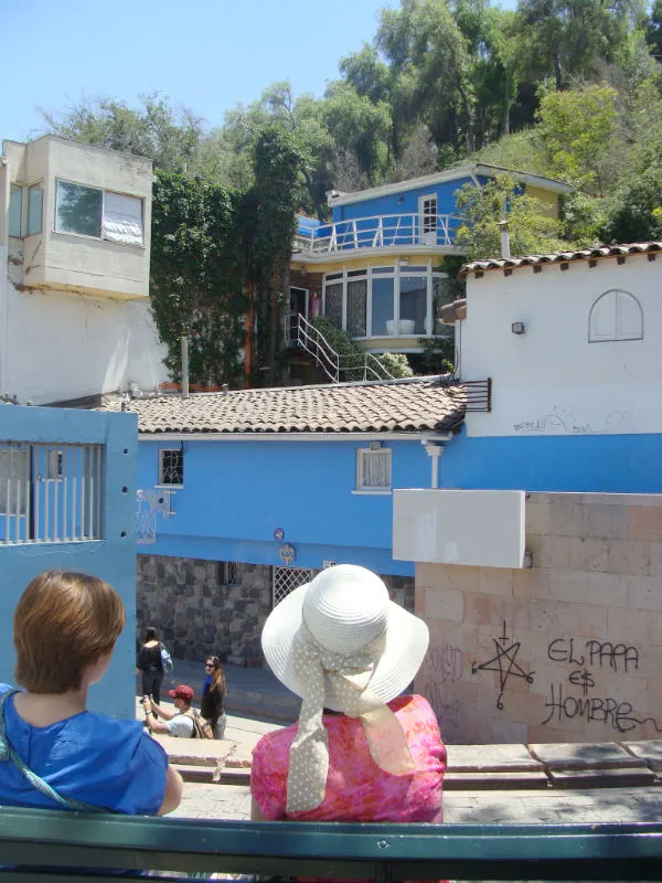 Señoras sentadas de espalda a la cámara mirando La Chascona, la casa de Pablo Neruda a los pies del Cerro San Cristóbal - Foto de Andrea Hoare Madrid