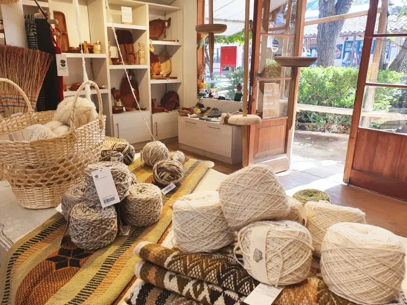 Interior de la sucursal de la tienda Artesanías de Chile en el Centro Artesanal Pueblito Los Dominicos, en primer plano lanas artesanales - Foto de Andrea Hoare Madrid