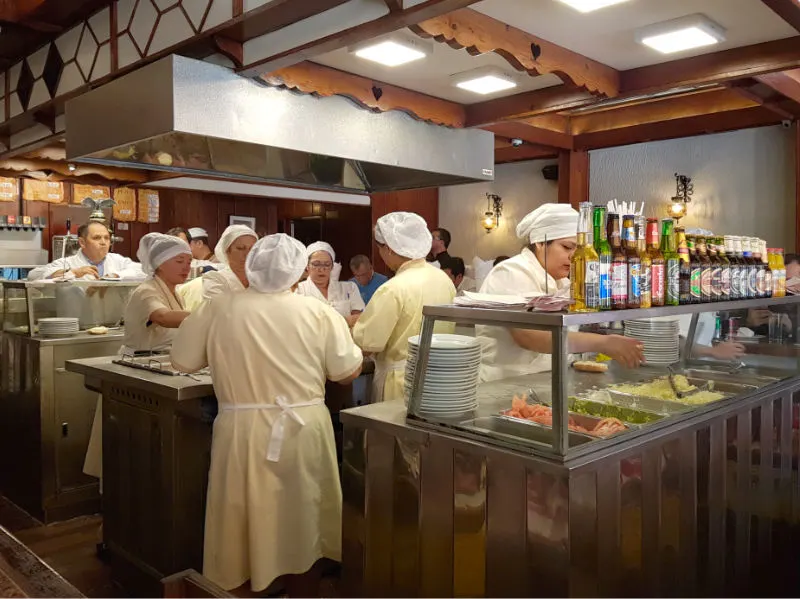 Señoras cocinando a la vista de los comensales en la Fuente Alemana de Santiago de Chile. Foto de Andrea Hoare Madrid